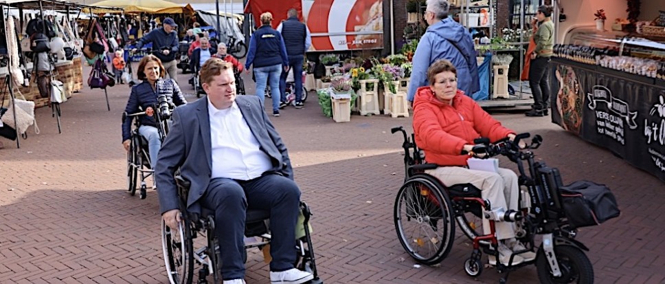 Twee mensen in rolstoel in dorpscentrum Borne.
