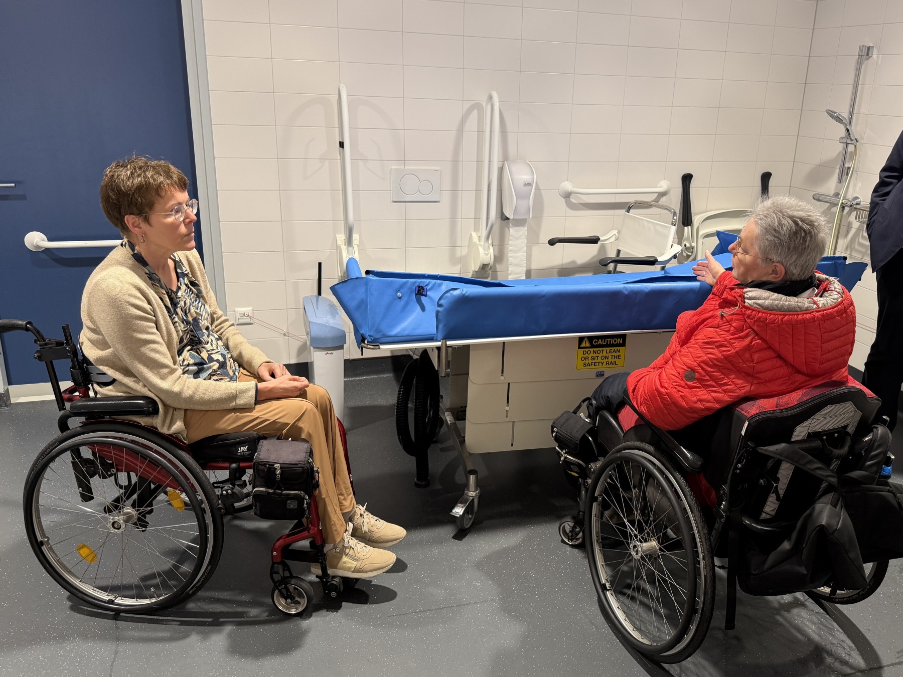 Foto: twee vrouwen in rolstoel in toegankelijk zwembad.